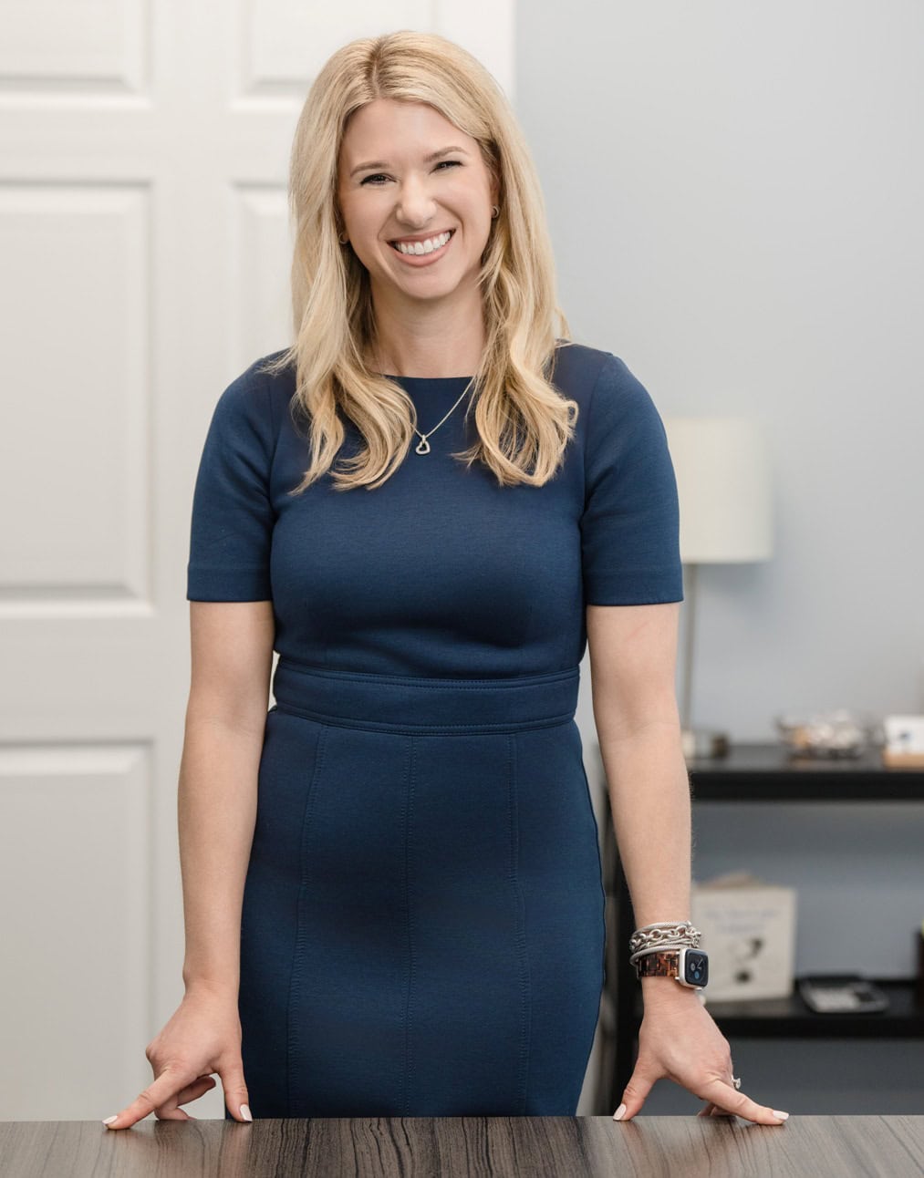 Evoto Raleigh Family Law Attorney Sarah Privette stands at her desk to warmly greet a victim of domestic abuse.